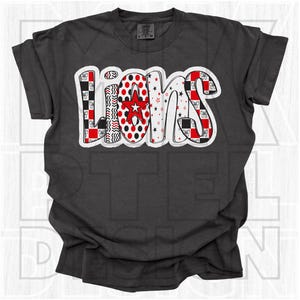 May include: Dark gray t-shirt with the word "LIONS" in a colorful, patterned design. The letters feature red, black, and white patterns, including polka dots, stars, and bows. A red star is in the center of the "O".