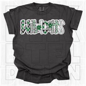May include: Dark grey t-shirt featuring the word "Wildcats" in a white, green, and black design. The word is outlined in white and features a mix of patterns, including checkerboard, polka dots, and wavy lines. The shirt is made of a soft material.