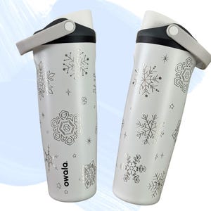 May include: A white ceramic mug with a black handle and the text "But First, Coffee" in a black, handwritten-style font. The mug is on a white surface.