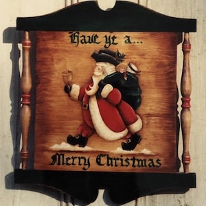 Puede incluir: Cartel de Navidad de madera con un Papá Noel pintado que lleva un saco y un vaso. El letrero dice "Have ye a... Merry Christmas" en escritura negra. El marco es verde oscuro y negro.