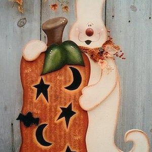 Może przedstawiać: Biały duch z czerwonym nosem i przyjaznym uśmiechem trzyma pomalowaną pomarańczową dynię z czarnymi gwiazdami i półksiężycami. Dynia ma zieloną łodygę i brązową górę.