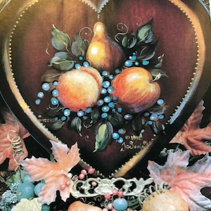 May include: Heart-shaped decorative tray featuring a still life of fruit. The tray has a dark red background with a gold border. The fruit includes peaches, pears, and grapes, with green leaves and blue berries.