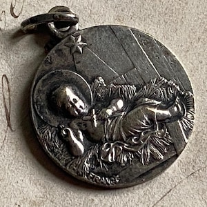 An antique French silver medal of the infant Jesus