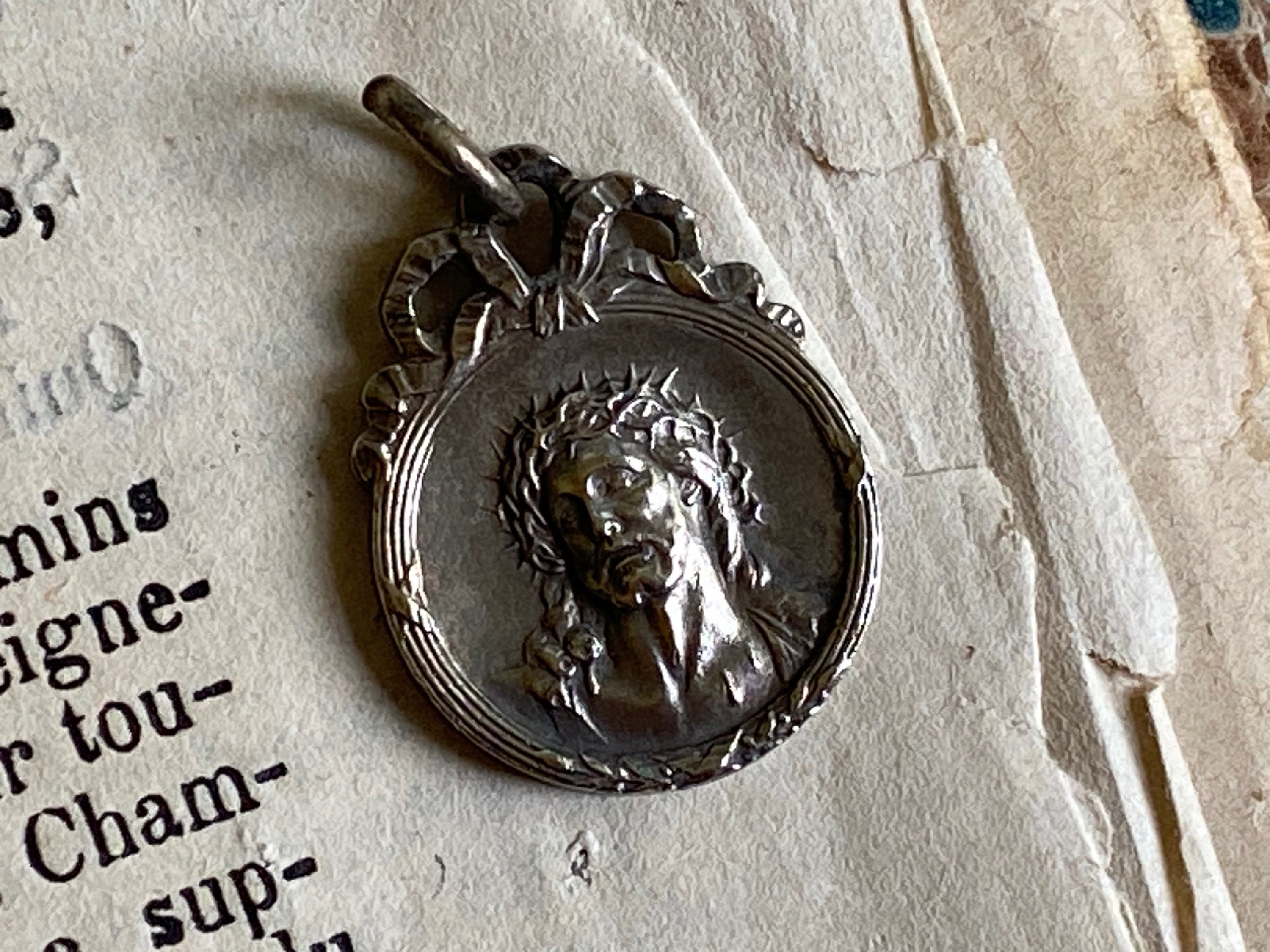 A vintage French medal of Christ crowned with thorns on the face and Our Lady of Rocamadour on the reverse