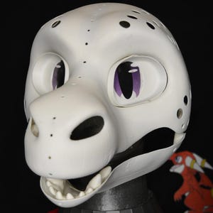 May include: A white dragon head with purple eyes and black spots. The head has an open mouth with white teeth and is mounted on a black and red base. The text "THE LAIR Le Terrier" is visible at the bottom.