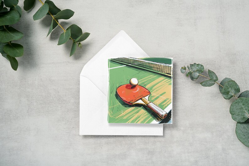 May include: A greeting card with a green and yellow illustration of a ping pong paddle and ball on a table.