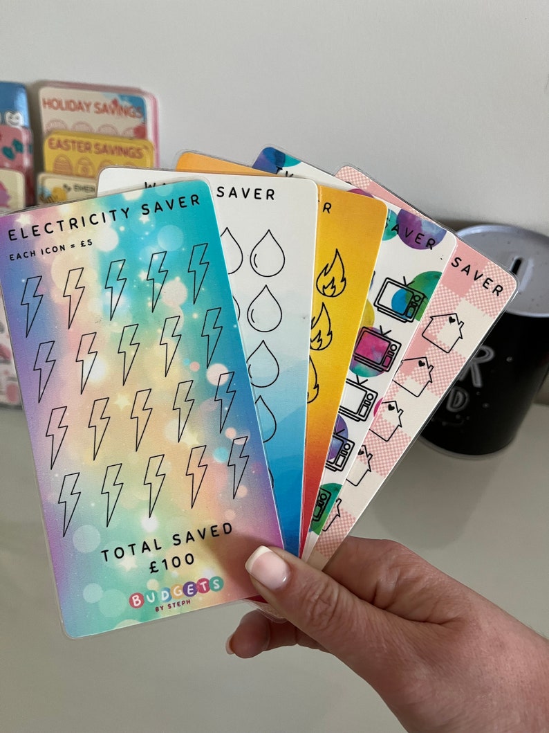 May include: A set of six colorful cards with different icons for tracking savings. The cards are labeled "Electricity Saver", "Water Saver", "Gas Saver", "Food Saver", "Entertainment Saver", and "Other Saver". Each card has a different color and features a unique icon. The cards are designed to help people track their savings and reach their financial goals.