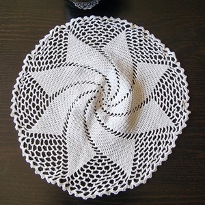 May include: White crocheted doily with a spiral design in the center.