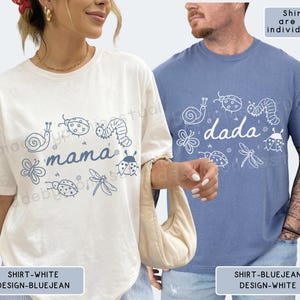 Op de afbeelding: Twee T-shirts, &eacute;&eacute;n wit en &eacute;&eacute;n blauw, elk met een grillig insectenontwerp. Het witte shirt zegt "mama" en het blauwe shirt zegt "dada". Beide shirts hebben een ronde hals en korte mouwen.
