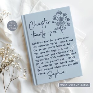 May include: A light blue hardcover book featuring a dark blue floral line art illustration and the text Chapter Twenty-five, followed by an inspirational message and the name Sophia in a script font, with a small circular badge stating More Color Options.