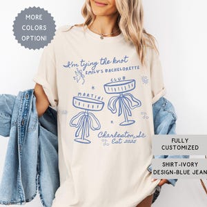 Comfort Colors® Personalized Coquette She&#39;s Tying the Knot Shirt, Custom Bow & Martini Bachelorette Party Favors, Destination Bach Tee Gift