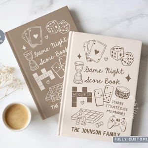 May include: Two hardcover score books with a light brown and a cream cover. The covers feature line art illustrations of playing cards, dice, an hourglass, dominoes, a word grid, a chessboard, and a game controller with the text Game Night Score Book.