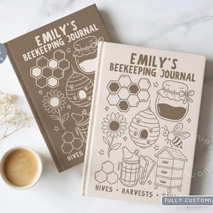 May include: Two hardcover journals titled Emily's Beekeeping Journal. The brown journal features honeycomb, a jar, a hive, and a flower. The cream journal features honeycomb, a jar, a bee, a flower, a smoker, and a hive with the text Hives Harvests.