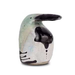 Può includere: Una scultura di uccello in ceramica con un lungo becco, dipinta in tonalità di verde, bianco e nero.