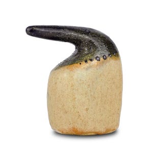 Può includere: Un vaso in ceramica con una forma unica e astratta. Il vaso ha un corpo marrone chiaro con una smaltatura verde scuro e nera sulla parte superiore. La smaltatura ha un motivo maculato.