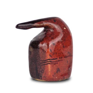 Può includere: Una piccola scultura in ceramica realizzata a mano di un uccello con un becco lungo e sottile. La scultura è smaltata in tonalità di rosso e nero.