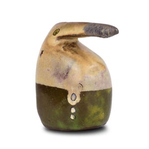 Può includere: Una piccola scultura in ceramica di un uccello con un lungo becco, dipinto in tonalità di marrone, verde e bianco.