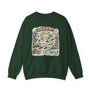 Op de afbeelding: Donkergroene sweatshirt met een kaartafbeelding van "Tug Hill NY". De kaart toont een winterlandschap met sneeuwscooters, bomen en een hut. De sweatshirt heeft een ronde hals en lange mouwen. De tekst "Tug Hill NY" is inbegrepen.