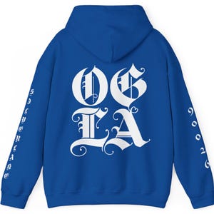 May include: A royal blue hoodie with white lettering that says "OG LA" on the back. The sleeves have white lettering that says "90026" on the right sleeve and "STAY TRUE" on the left sleeve.