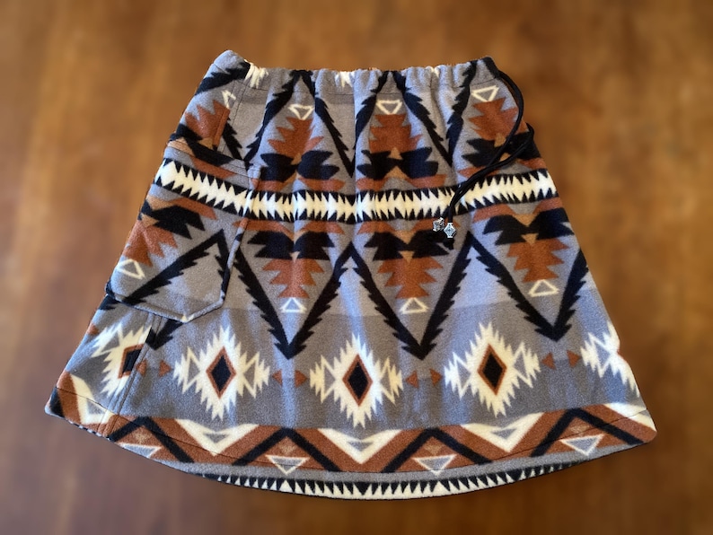 Fleece Bum Warmer skirt. A-line with pocket large enough or a phone. beaded drawstring waist. Print: Black Raymi Southwest