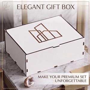 May include: A rectangular white wooden gift box with a dark brown geometric line art logo on the lid. The box features visible interlocking joints at the corners. Text on the image reads ELEGANT GIFT BOX and MAKE YOUR PREMIUM SET UNFORGETTABLE.