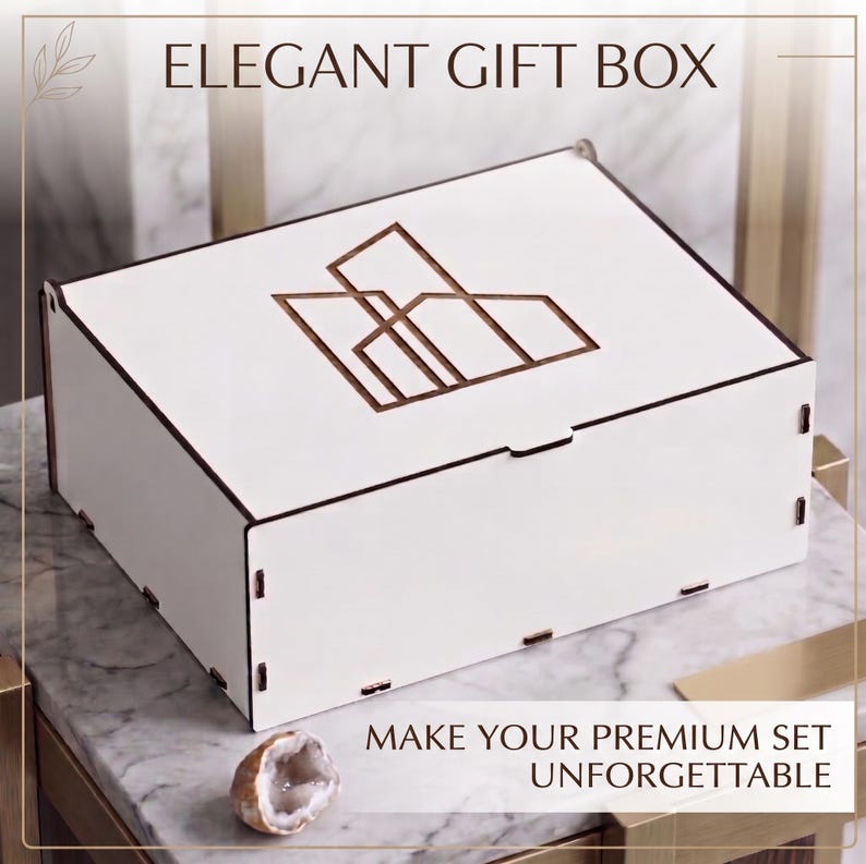 May include: A rectangular white wooden gift box with a dark brown geometric line art logo on the lid. The box features visible interlocking joints at the corners. Text on the image reads ELEGANT GIFT BOX and MAKE YOUR PREMIUM SET UNFORGETTABLE.