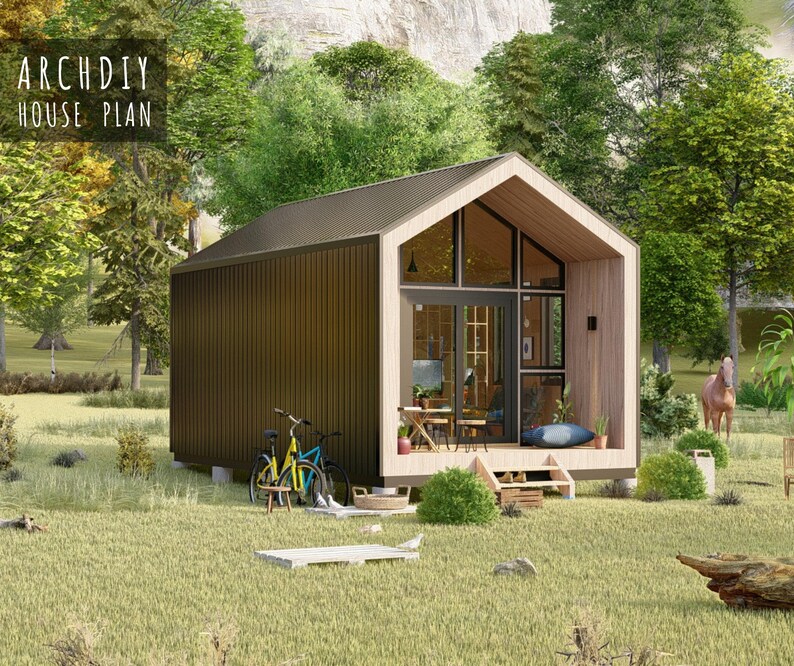 Side view exterior render of the modern tiny cabin with vertical dark walls, a sloped roof, and a bicycle parked on the grass.