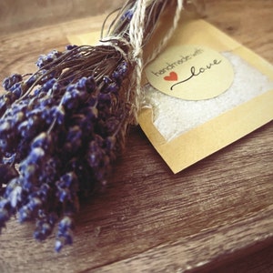 May include: A small brown paper bag with a white label that says "handmade with love" and a red heart. A bundle of dried lavender flowers is next to the bag.