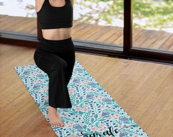May include: A blue and green yoga mat with a floral pattern and the name "Sarah" printed on it. A person is doing yoga on the mat.