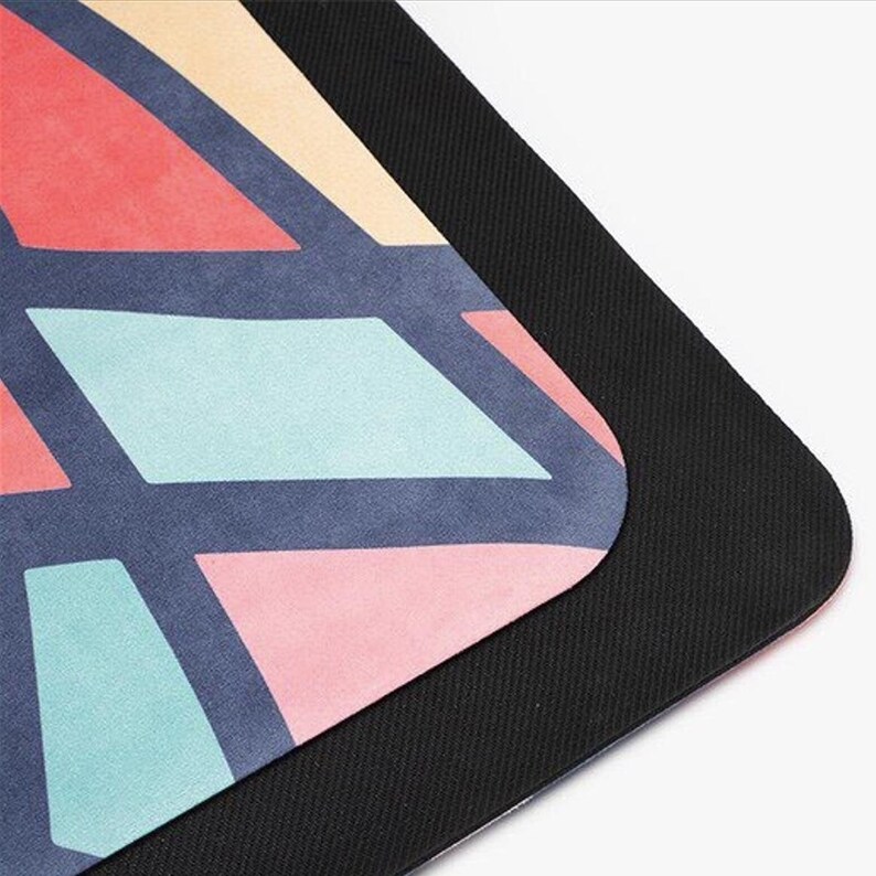 May include: A colorful yoga mat with a geometric pattern in shades of pink, blue, and gray. The mat has a black non-slip backing.
