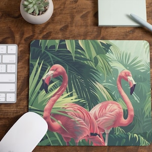 May include: A pink flamingo mouse pad with a tropical jungle design featuring lush green palm leaves and two pink flamingos.
