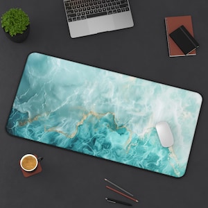 May include: A blue and gold marble-patterned desk mat with a white computer mouse on top. The mat is on a black surface.