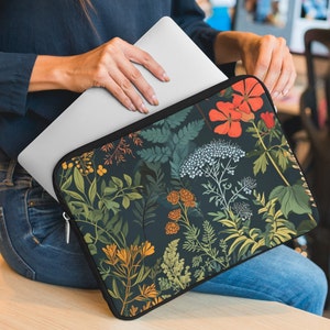 May include: A laptop sleeve with a floral pattern. The sleeve is black with a variety of colorful flowers and leaves. The sleeve is made of a soft, durable material and is perfect for protecting your laptop.