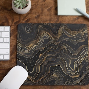 May include: A black and gold mouse pad with a swirling, abstract pattern. The pattern resembles marble or a topographic map.