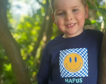 Welsh 'Hapus'  emoji smiley face checkered pattern jumper. Smiley faces cool trending check jumper for boys .Siwmper gwyneb hapus navy.
