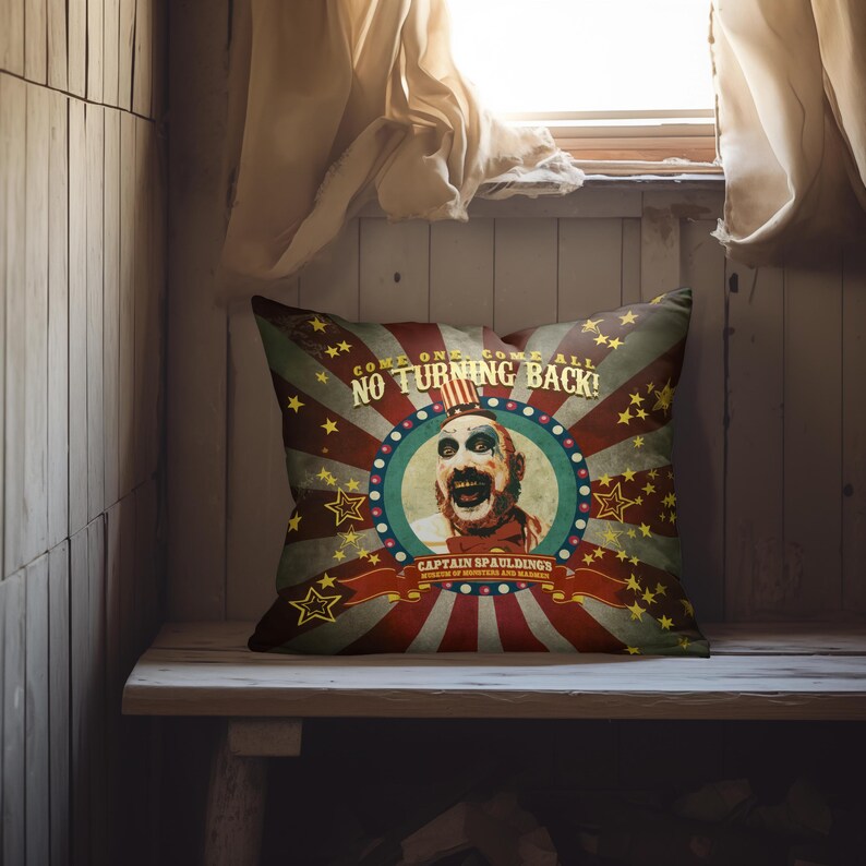 May include: A red, white, and blue pillow with a vintage circus theme. It features a clown with a creepy smile and the text "Come One Come All No Turning Back!" and "Captain Spauldings Museum of Monsters and Madmen".
