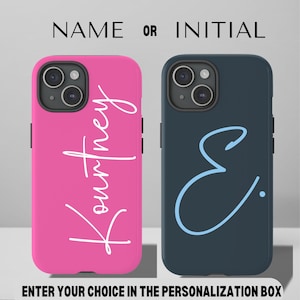 May include: Two iPhone cases, one pink with the name "Kourtney" in white script, and one dark blue with the initial "E" in light blue script.  NAME OR INITIAL is written above the cases.
