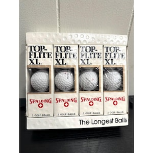 May include: A package of Spalding Top-Flite XL golf balls. Each of the four boxes contains three golf balls. The boxes are white with black and red text. The text "The Longest Balls" is printed on the bottom of the package.