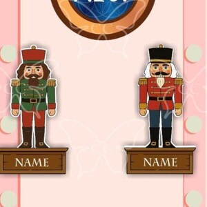 May include: Two cartoon nutcracker figures, one in green and red, the other in red and blue, stand on wooden platforms. Each platform has the word "NAME" printed on it. The background is light pink with decorative elements.