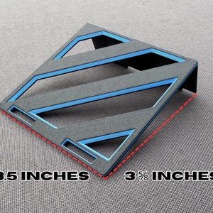 May include: A gray and blue geometric desk organizer. The organizer is 3.5 inches by 3 5/8 inches. The design features blue accents and a diagonal pattern. The product is made of a textured material.