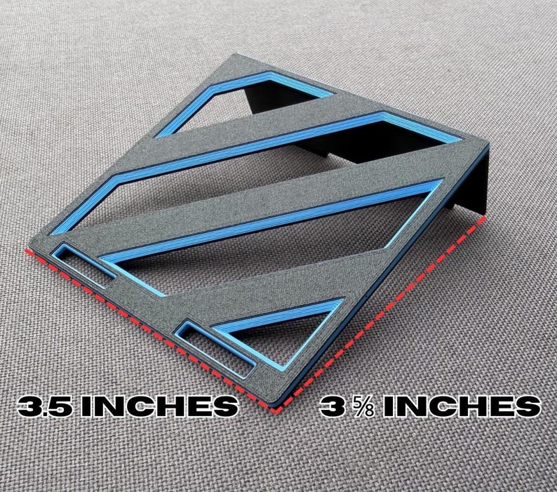 May include: A gray and blue geometric desk organizer. The organizer is 3.5 inches by 3 5/8 inches. The design features blue accents and a diagonal pattern. The product is made of a textured material.