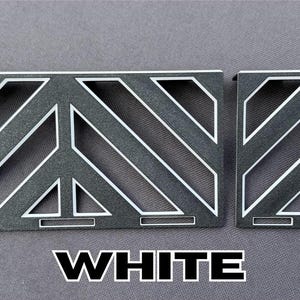 May include: Two gray metal decorative panels with white diagonal and geometric designs. The word "WHITE" is displayed in bold white letters at the bottom of the image. The panels are likely for decorative purposes.