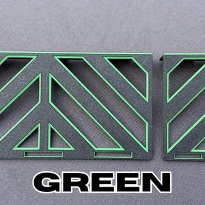 May include: Two geometric metal pieces, one rectangular and one square, with a black base and bright green diagonal lines and accents. The word "GREEN" is printed in bold white letters at the bottom.