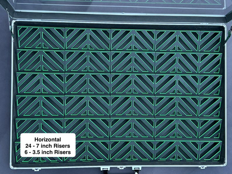 May include: A silver case with a clear lid, filled with rows of black risers with green neon-like accents. The risers are arranged in a repeating chevron pattern. Text on a white rectangle reads "Horizontal 24 - 7 inch Risers 6 - 3.5 inch Risers."