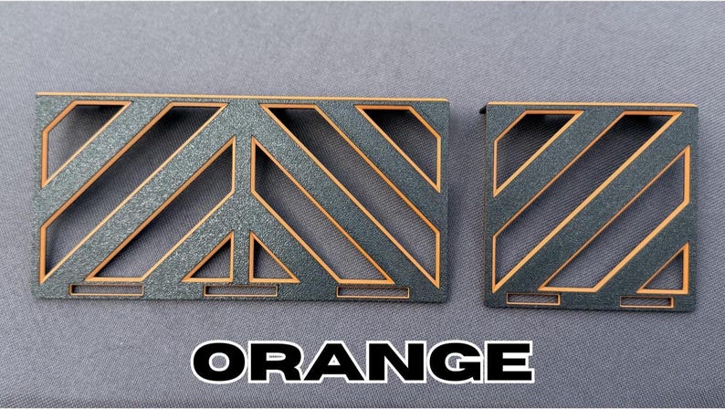 May include: Two decorative wooden panels with a geometric design. The panels are dark gray with orange accents and the word "ORANGE" in white block letters. The panels have a diagonal pattern.