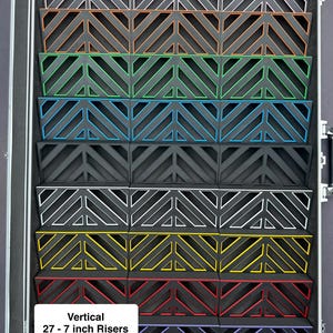 May include: A black case with multiple vertical risers, each with a unique color trim. The risers are approximately 27 inches in height and feature a geometric design. The text "Vertical 27 - 7 inch Risers" is visible.