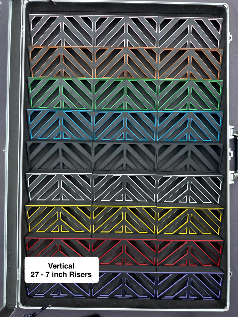 May include: A black case with multiple vertical risers, each with a unique color trim. The risers are approximately 27 inches in height and feature a geometric design. The text "Vertical 27 - 7 inch Risers" is visible.