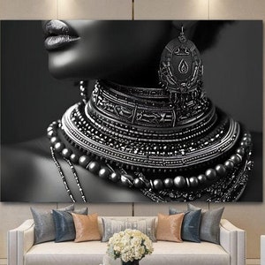 Puede incluir: Retrato en blanco y negro de una persona que lleva un collar y pendientes grandes y ornamentados. El collar est&aacute; hecho de m&uacute;ltiples capas de cuentas y metal.