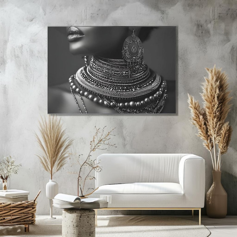 Puede incluir: Foto en blanco y negro de una mujer con un collar grande y adornado de plata con un colgante en forma de corona. El collar est&aacute; formado por capas de cuentas y cadenas.