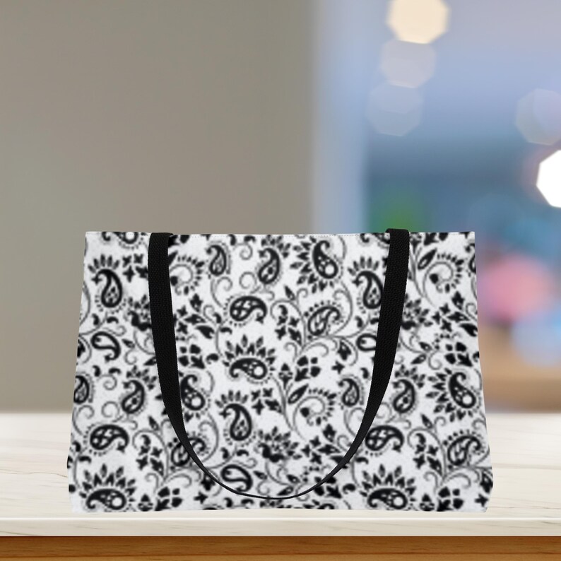 This Black And White Paisley Tote Bag is a large travel bag perfect for weekend getaways or trips to the beach. It makes a great gift for moms looking for a stylish and functional bag